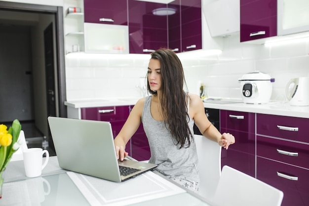 Mujer Atractiva Joven Que Trabaja En La Computadora Portátil En La Cocina Mujer Escribiendo En 1971