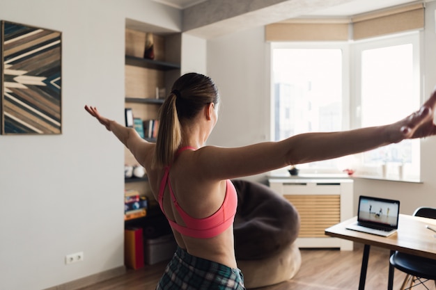 Mujer bailando en casa siguiendo lecciones en video en la computadora  portátil | Foto Gratis