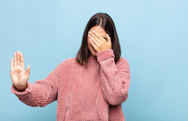 Mujer Bonita Joven Que Cubre La Cara Con La Mano Y Pone La Otra Mano Al Frente Para Detener La 2696