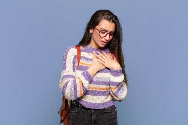 Mujer bonita joven que parece triste herida y con el corazón roto