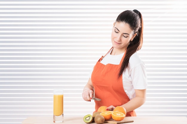 Mujer Cortando Fruta En La Cocina Foto Premium