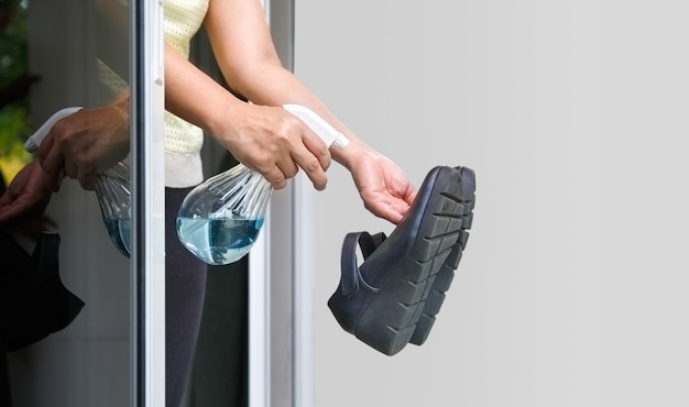Mujer desinfectando sus zapatos en el balcón | Foto Premium
