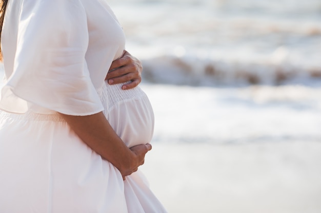 Mujer Embarazada Con Elegante Vestido Blanco Sobre El Mar Foto Premium