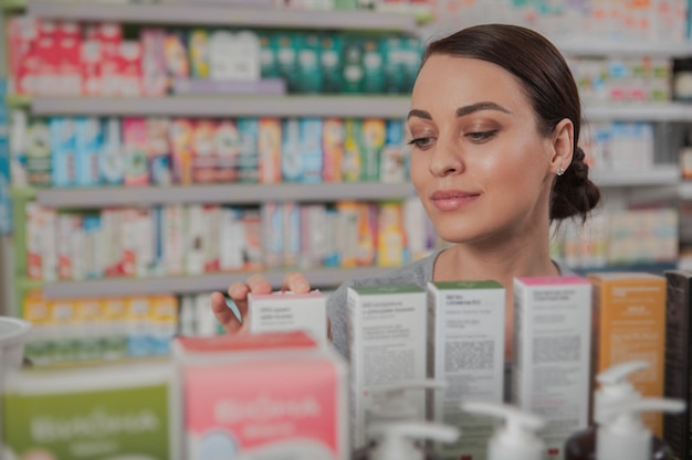 Mujer encantadora de compras en la farmacia Foto Premium