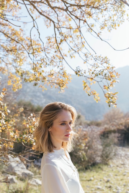 Mujer estar de pie, debajo, árbol Foto gratis