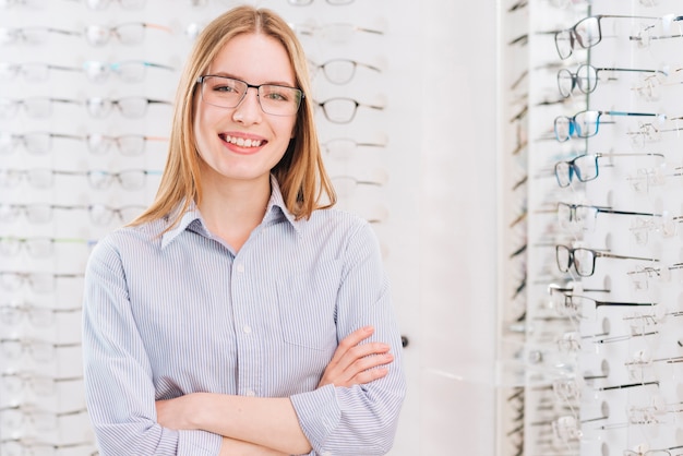 Mujer feliz buscando gafas nuevas en óptico Foto gratis