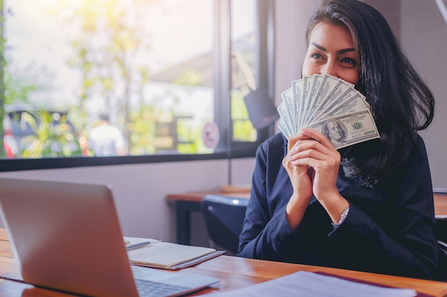 Mujer feliz con el dinero de los dólares en su mano. | Foto Premium