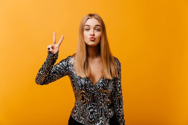 Mujer Glamorosa Divertida Posando En Naranja Con El Signo De La Paz Retrato Interior De Una 8108