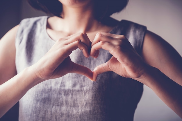 Mujer haciendo sus manos en forma de corazón seguro de salud de corazón Foto Premium