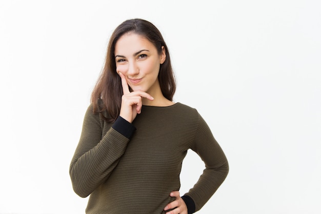 Mujer hermosa astuta pensativa que toca la barbilla Foto gratis