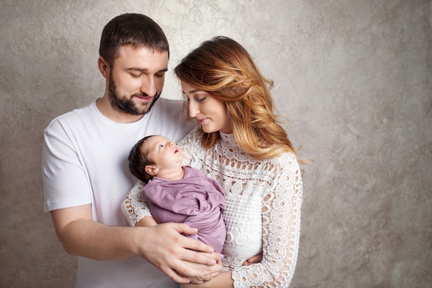 Mujer Y Hombre Con Un Recien Nacido Mama Papa Y Bebe Retrato De Familia Sonriente Con Recien Nacido En Las Manos Copyspace Foto Premium