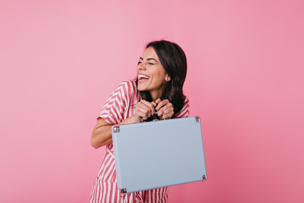 La Mujer Joven Alegre Se Divierte Y Se Rie Genuinamente Chica Hace Una Broma Tomando La Maleta Azul De Otra Persona Foto Gratis