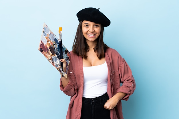 Mujer Joven Artista Sosteniendo Una Paleta Sobre La Pared Azul Riendo