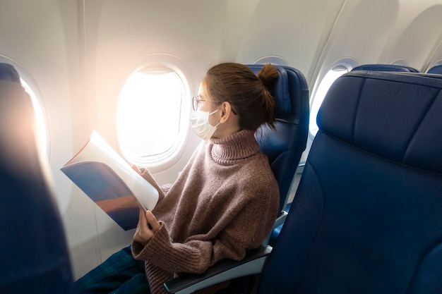 Foto Premium | Una mujer joven con máscara facial viaja en avión, nuevo  viaje normal después del concepto de pandemia covid-19