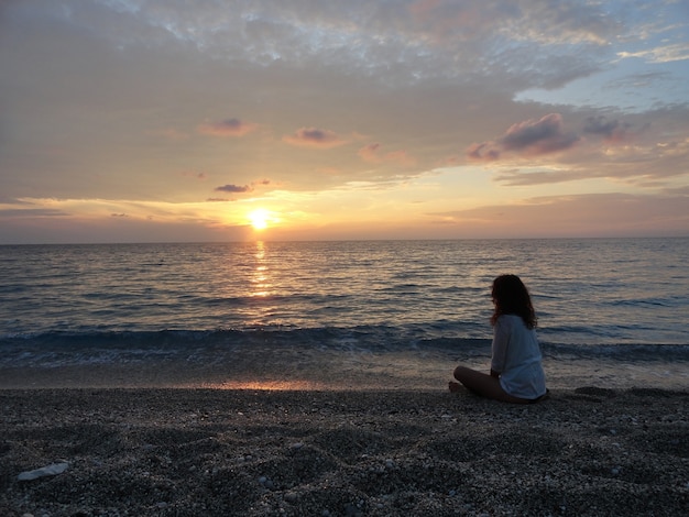 Mujer Joven Meditando En Una Playa Griega Al Atardecer Foto Premium