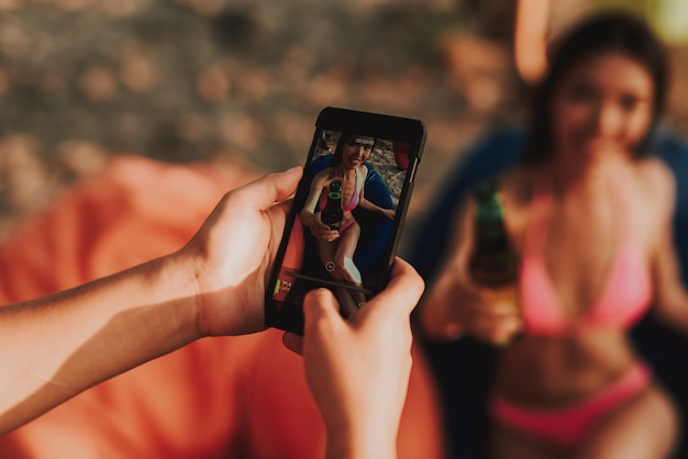 Mujer joven en poses del traje de baño para la foto en la playa. Foto Premium