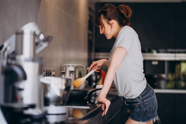 Mujer Joven Preparando El Desayuno En La Cocina Por La Mañana Foto Gratis 