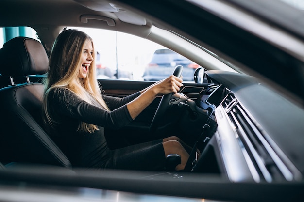 Mujer Joven Probando Un Automóvil Desde Una Sala De Exposición De Automóviles Foto Gratis 