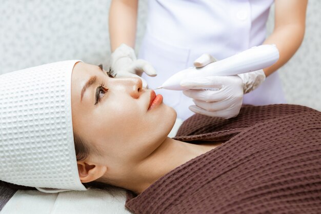 Mujer joven recibiendo su tratamiento de belleza por un médico en una ...