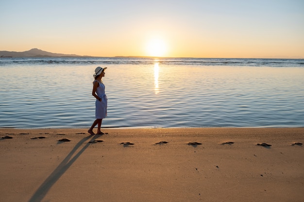 Mujer Joven Con Sombrero De Paja Y Un Vestido Caminando Sola En La Playa De Arena