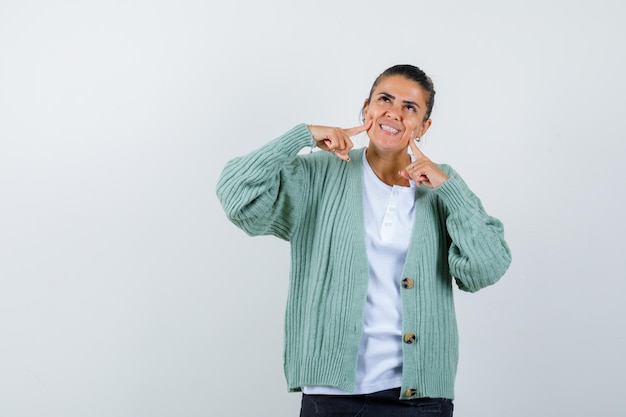 Mujer Joven Sonriendo Y Poniendo Los Dedos índices En Las Mejillas Con Camisa Blanca Y Chaqueta 5675