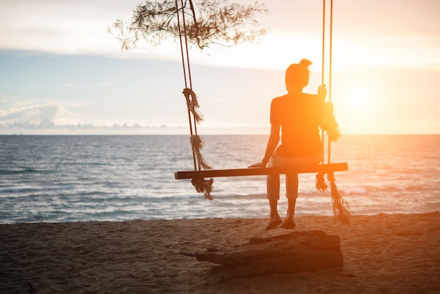 Mujer Joven Viendo Puesta De Sol Solo Sentado En Columpios En La Playa Al Atardecer Foto Premium 4749