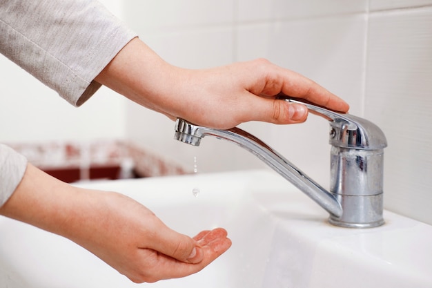 mujer-lava-manos-lavabo-abre-grifo-falta-agua_156359-245