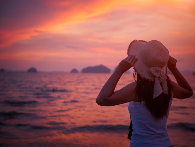 La Mujer Lleva Sombrero De Verano Y Esta Sola En La Playa Durante El Atardecer Foto Premium