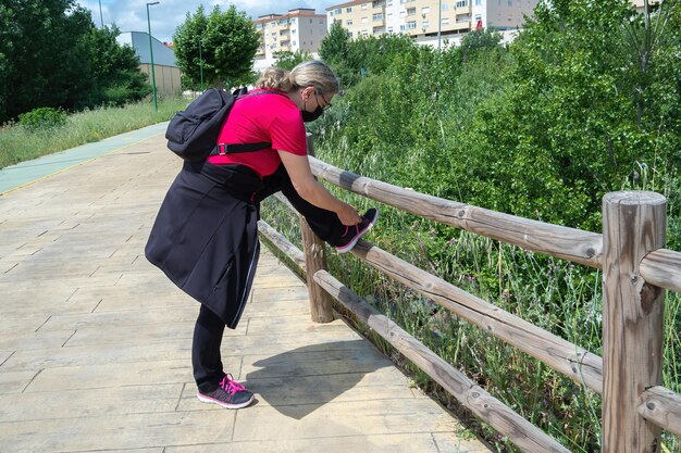 Mujer Madura Ata Los Cordones De Sus Zapatos Deportivos Despu S De