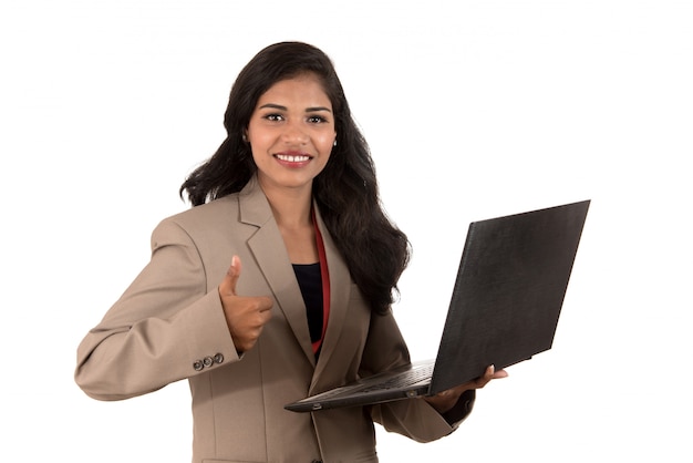 Mujer de negocios emocionada feliz que sostiene la computadora portátil