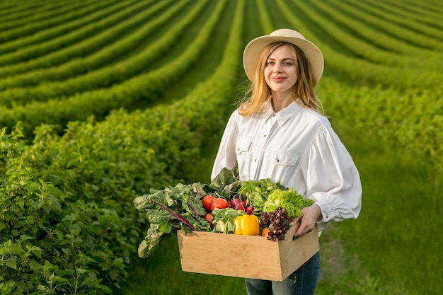 Mujer que sostiene la cesta de verduras Foto gratis