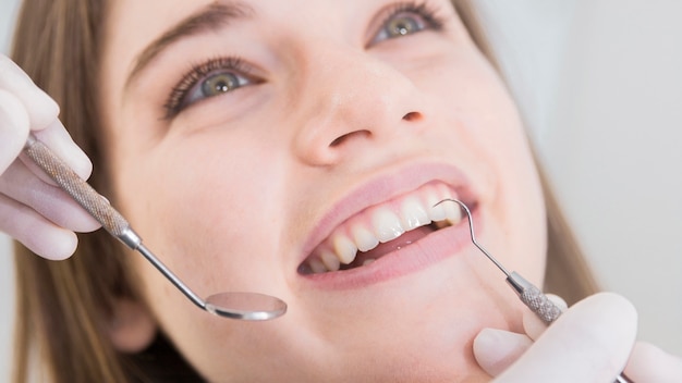 Mujer que tiene dientes examinados en dentistas Foto gratis