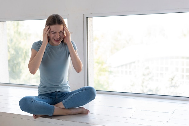 Mujer que tiene un dolor de cabeza con espacio de copia Foto gratis
