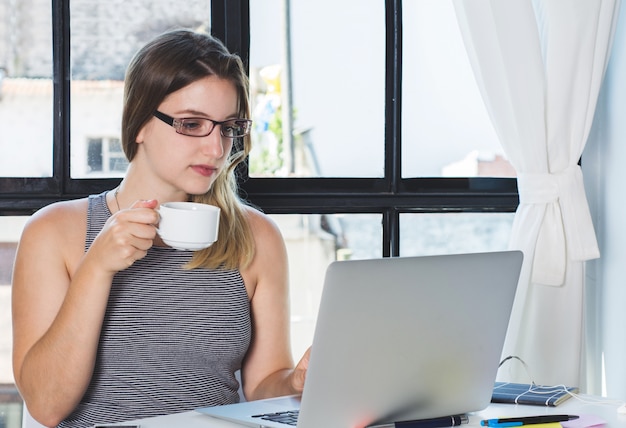 Mujer que trabaja en la computadora portátil en casa. | Foto Premium