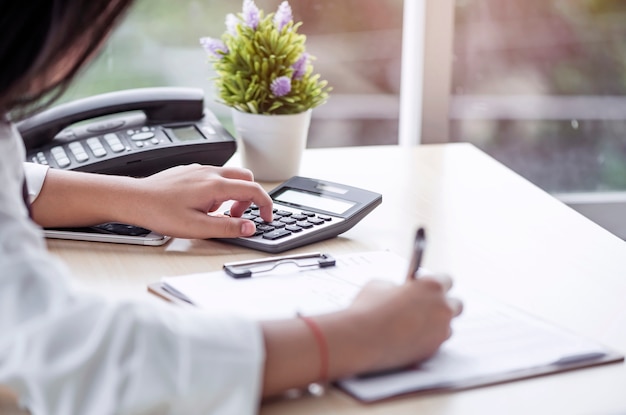 Mujer Que Usa La Calculadora Y Haga Una Nota Foto Premium