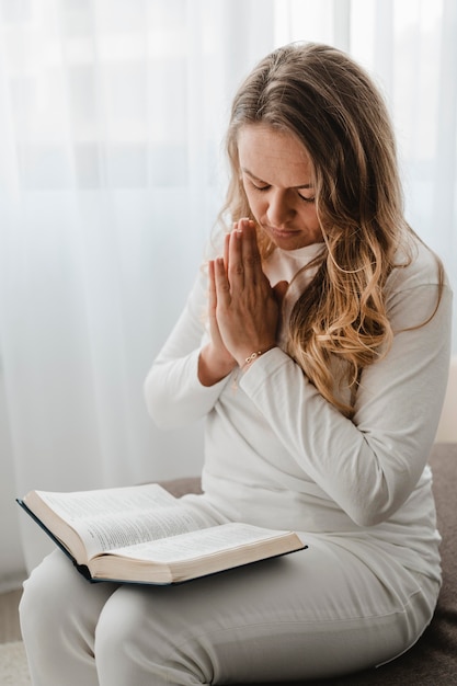 Mujer Rezando Mientras Lee La Biblia Foto Gratis