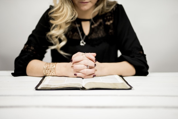 Mujer Rubia Leyendo Una Biblia Sobre La Mesa Foto Gratis