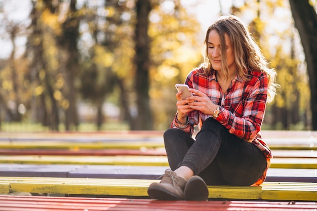 Mujer Sentada En Un Banco En El Parque Foto Gratis