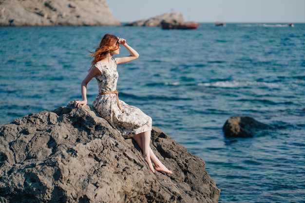 Mujer Sentada En La Orilla Del Mar Alrededor De Las Rocas Foto Premium