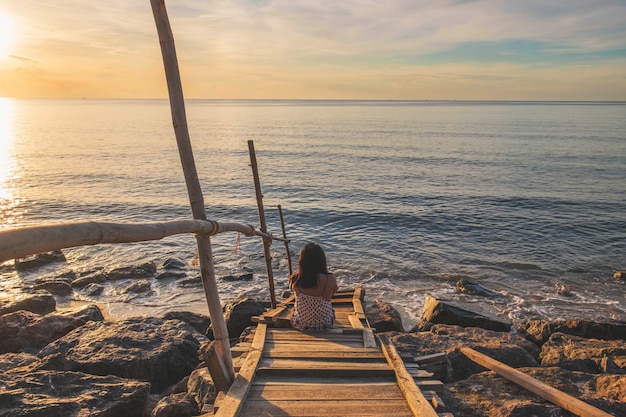 Una Mujer Sentada Sola En La Playa En Verano Foto Premium