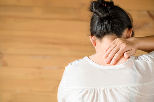 Mujer sintiéndose agotada y sufriendo de dolor de cuello. Foto gratis