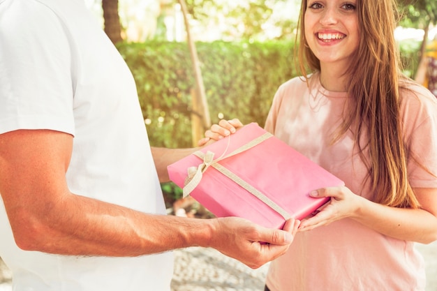 Mujer sonriente dando regalo de san valentín a su novio Foto Gratis