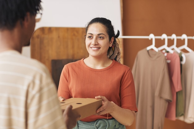 Mujer Sonriente Joven Dando El Paquete Embalado Al Repartidor Que Trabajan En El Servicio De 4925