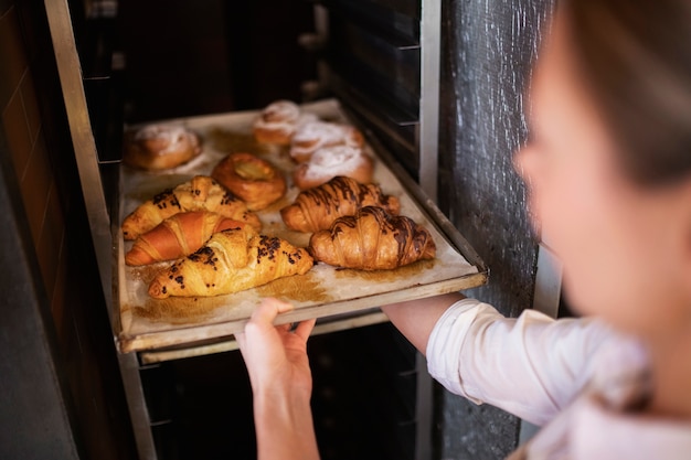 Mujer Sosteniendo La Bandeja Con Croissant De Cerca Foto Gratis