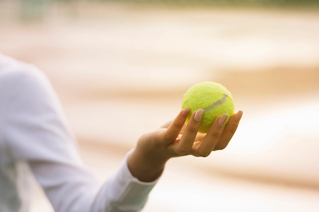 Mujer sosteniendo una pelota de tenis en una mano | Foto Gratis