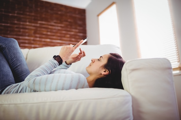 Mujer con teléfono móvil en casa | Foto Premium