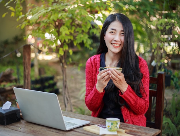 Mujer tomando café y trabajando con la computadora portátil en el ...