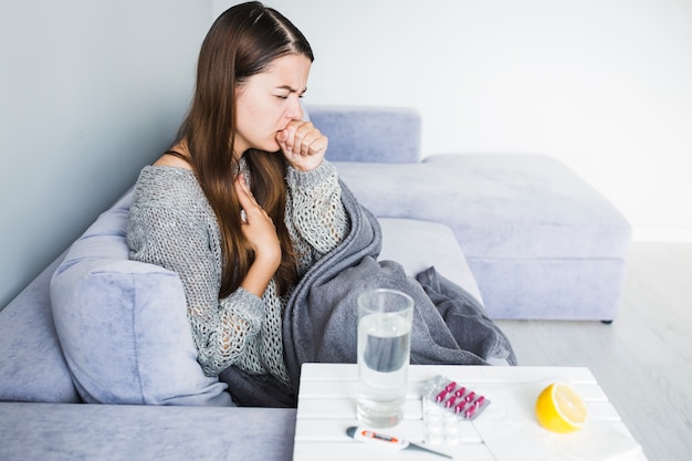 Mujer tosiendo y medicamentos 
Termómetro

enfermedades típicas del invierno