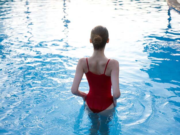 Mujer en traje de baño rojo subió hasta la cintura en la vista