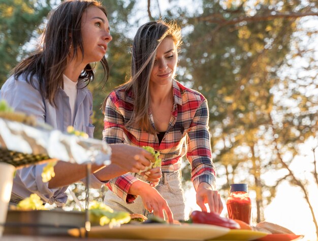 Mujeres Arreglando Comida Deliciosa En La Mesa Para Que Los Amigos Se Unan Foto Gratis 1589